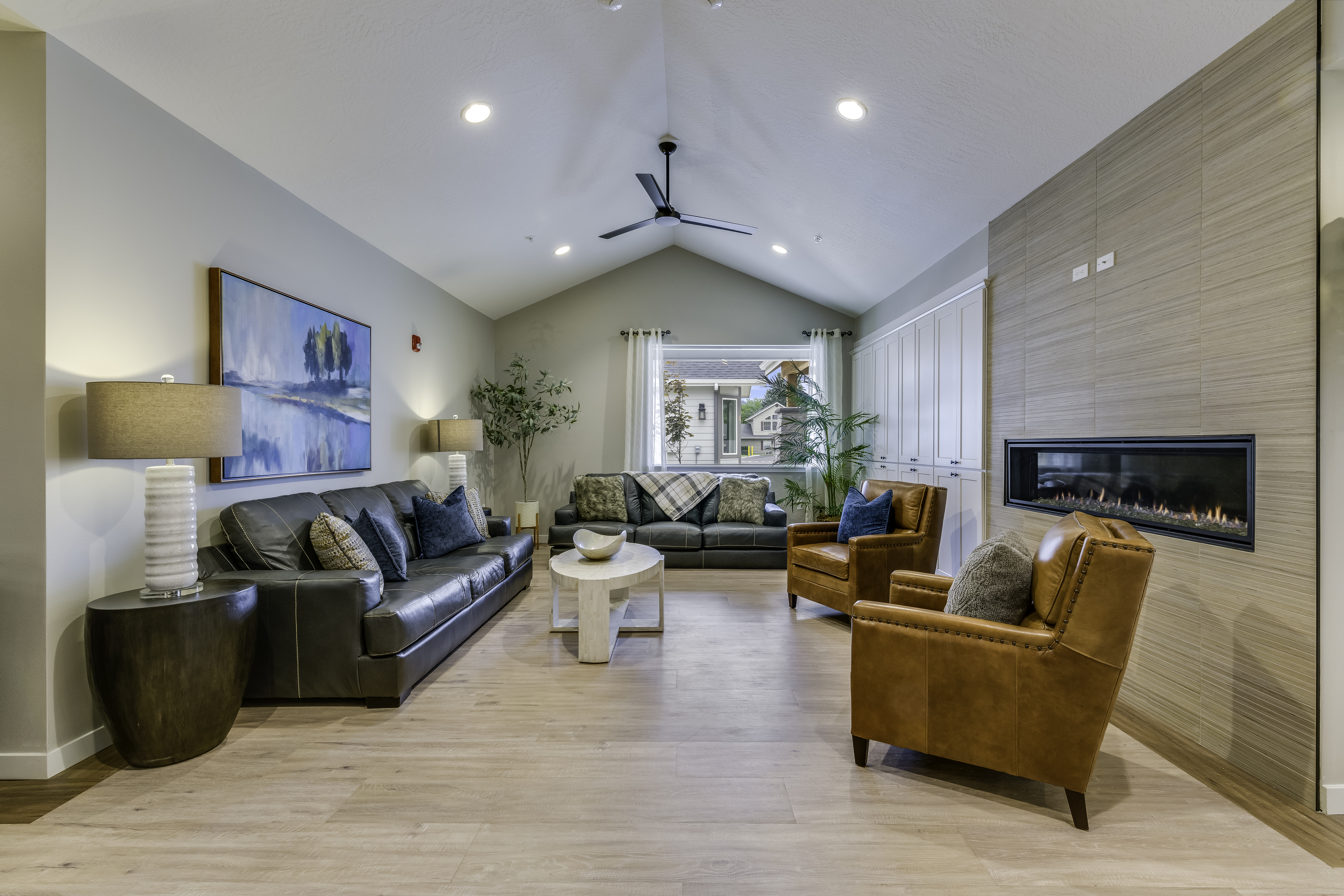 sophisticated living room with a black leather couch and brown arm chairs