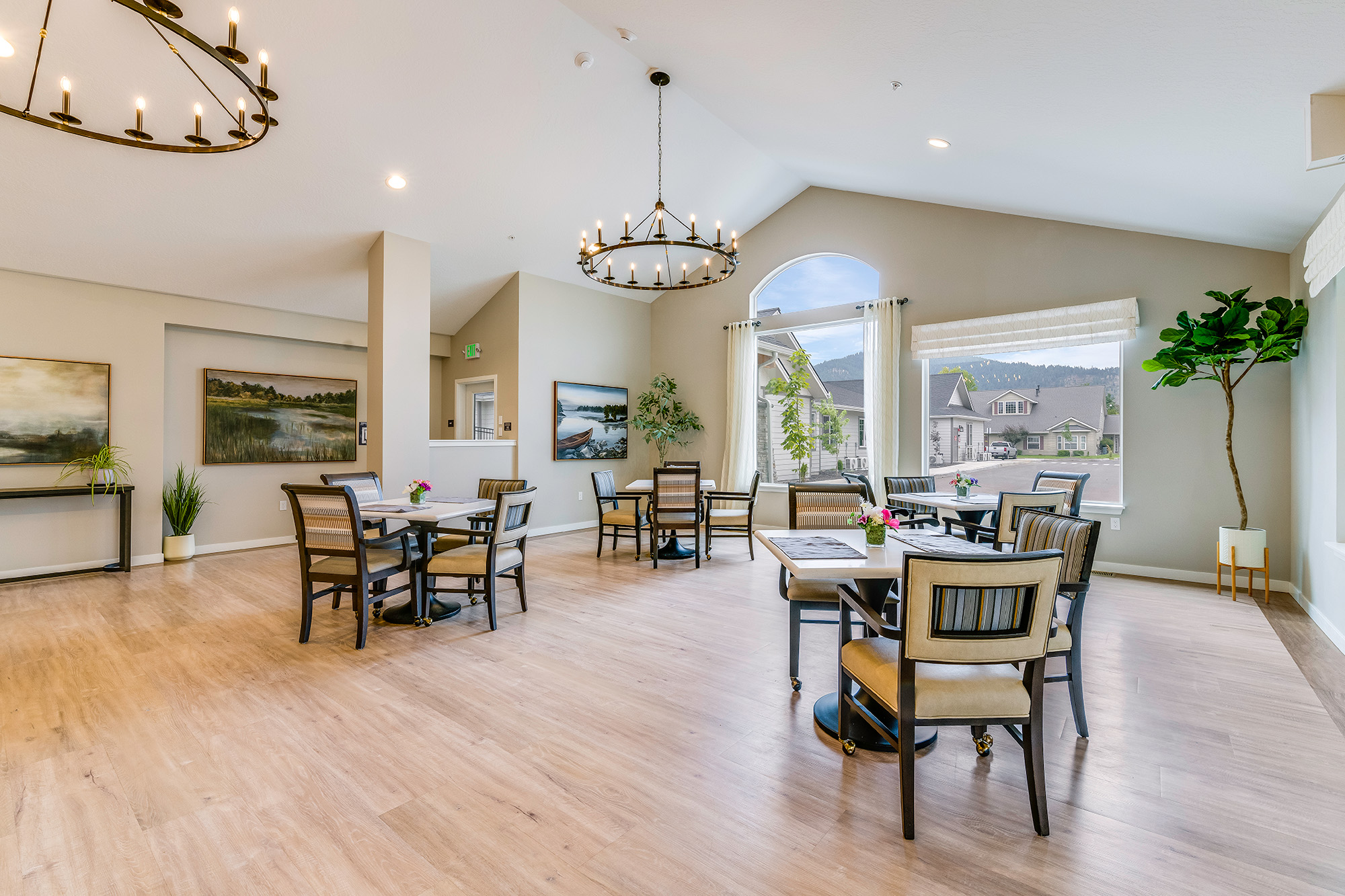 large common area with large windows and four tables with chairs