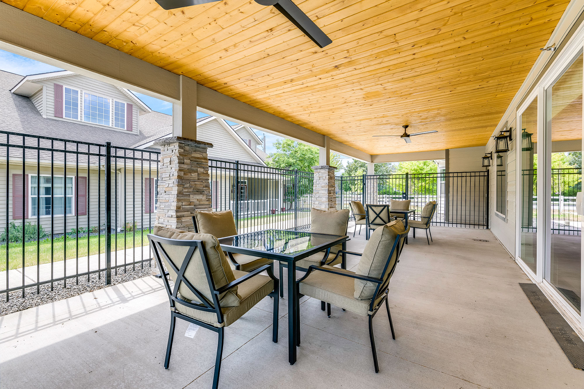 outdoor covered patio area with two sets of tables and chairs